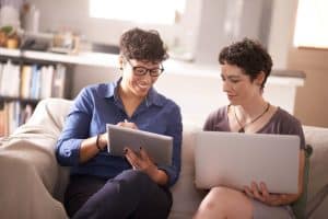 Couple looking at a laptop and a tablet together